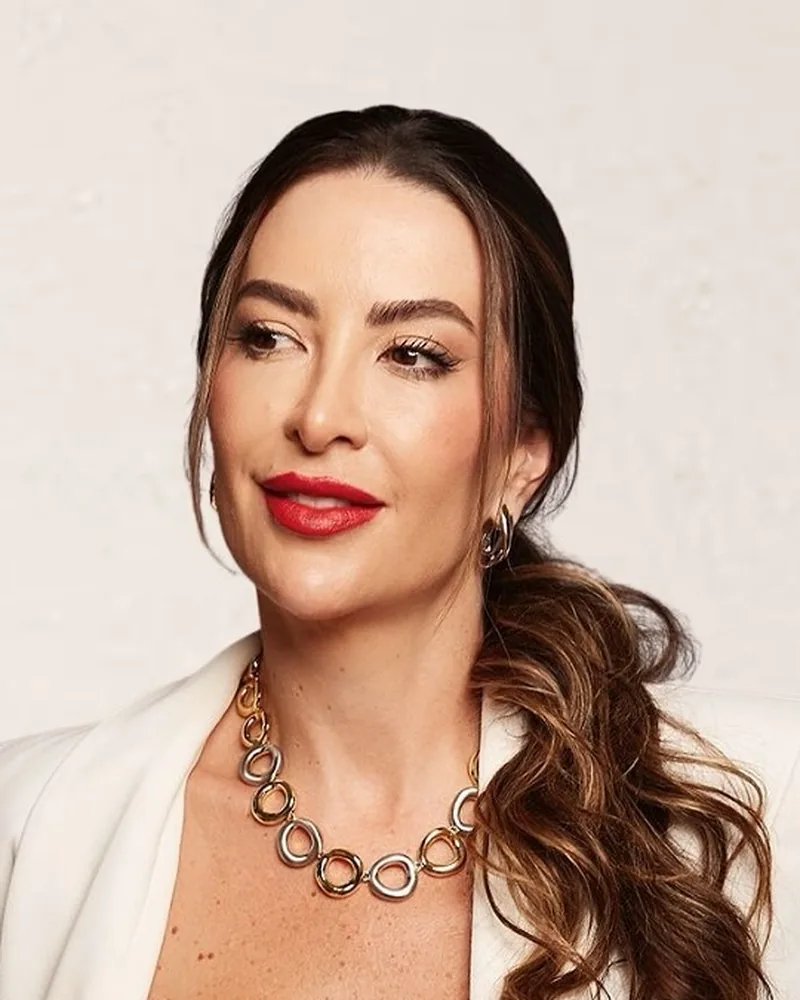 Retrato da Dra. Patrícia Toniazzo, com colar dourado e blazer branco, em foto editorial
