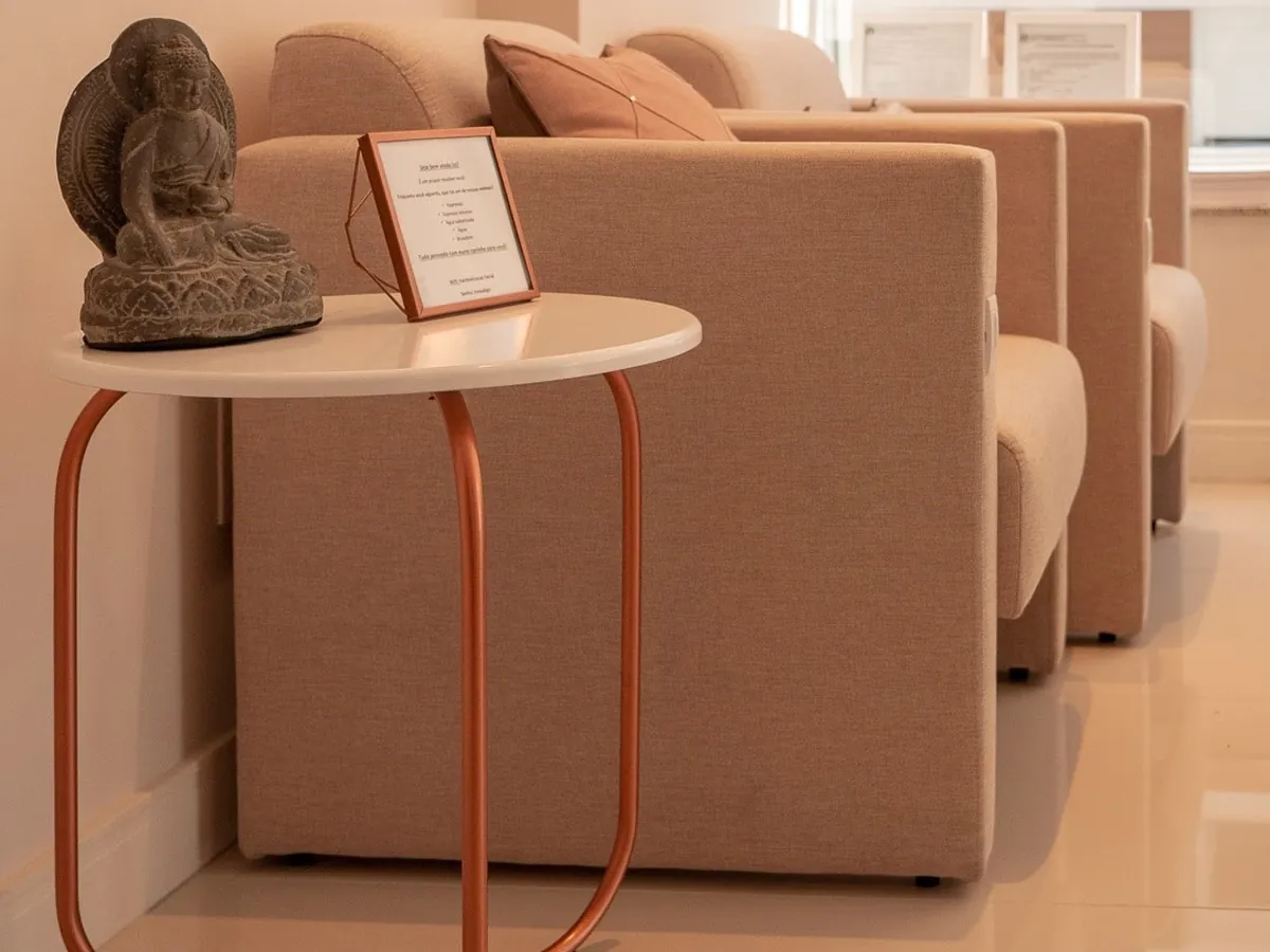 Sala de espera do consultório, com poltronas e decoração em tons claros