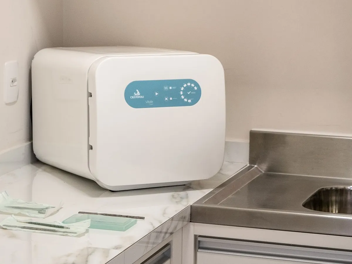 Área de esterilização de instrumentos, com autoclave e bancada em inox